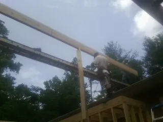 Carpenter setting a ridge beam over a new addition frame — Ice Dam Removal by Roofing Brothers in North Bay