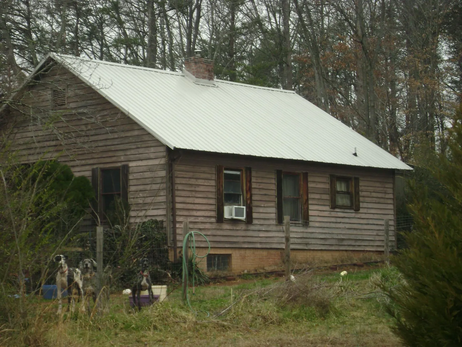 White metal roof on an old wood sided farmhouse, from a Metal Roof Installation job in North Bay